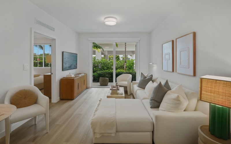 Open-concept living room with a sectional sofa and sliding doors to a covered private patio at Sereno in Sunrise, FL