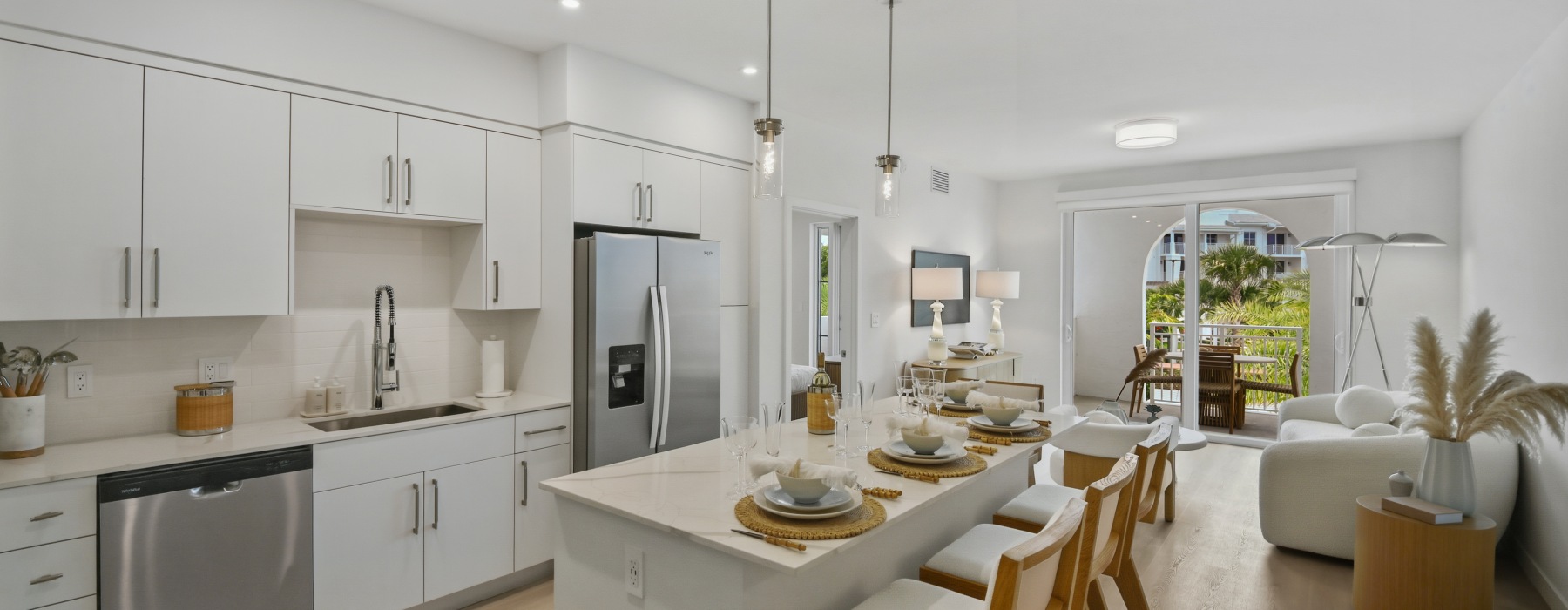 Modern kitchen with a quartz waterfall island and stainless steel appliances open to the living room at Sereno
