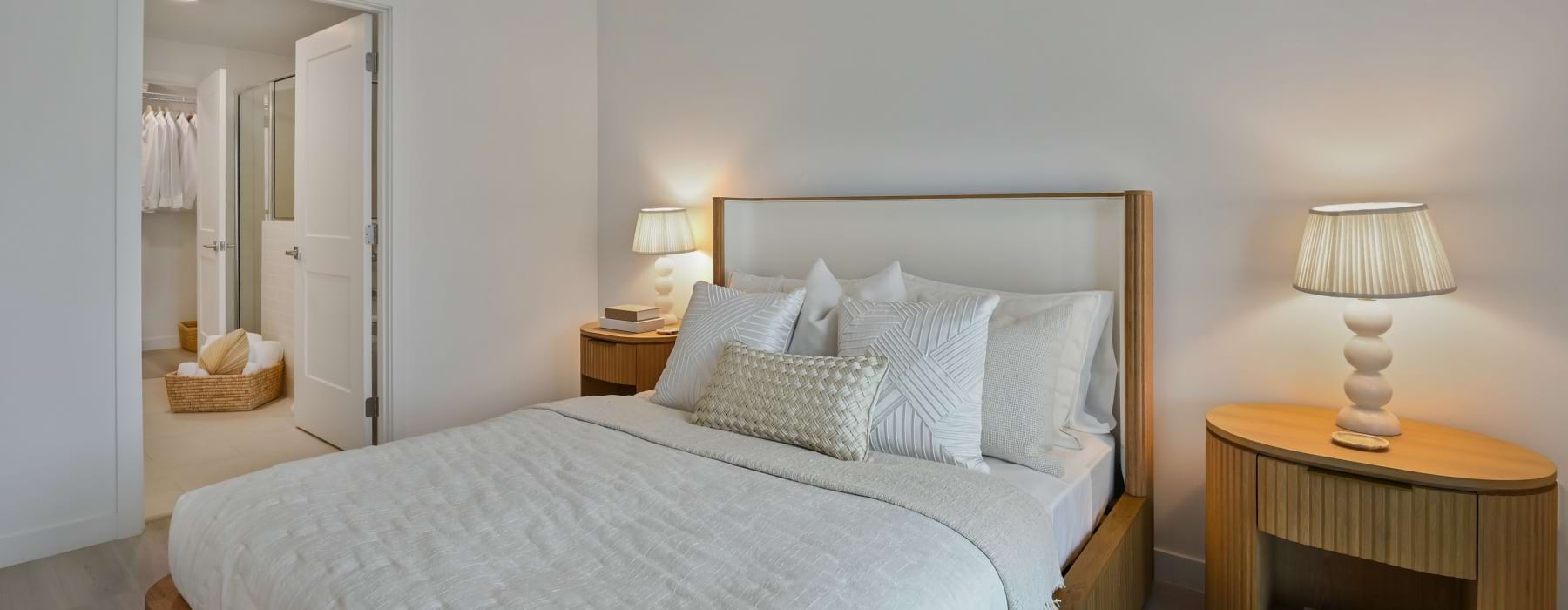 Bedroom with a queen bed, ensuite bath, and walk-in closet at Sereno apartments in Sunrise, FL