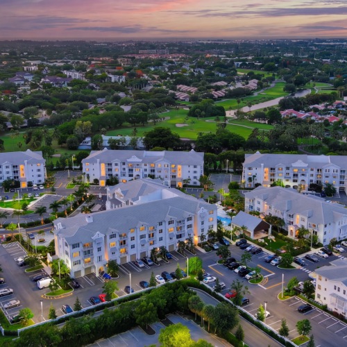 Aerial view of the Sereno apartment community in Sunrise, FL, showing all buildings, the pool, and a nearby golf course