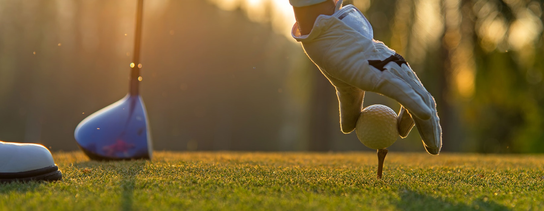 man teeing a ball on golf course