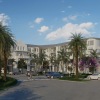 a building with palm trees and cars in front of it